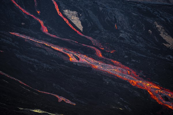 Erupting volcano with lava fountains and lava field