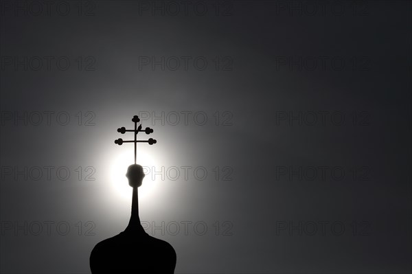 Double cross with dove on a church tower in backlight