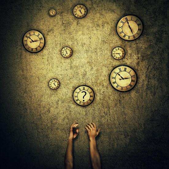 Abstract idea as human hands stretched out and juggling with a lot of clocks set to different times