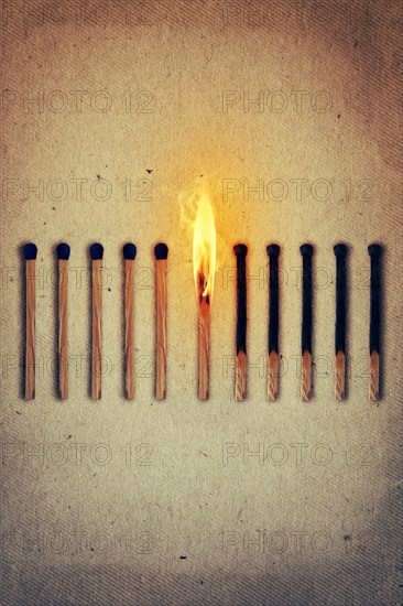 Burning match standing middle a row of whole