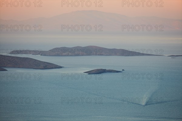 View of offshore islands and ship in front of sunrise