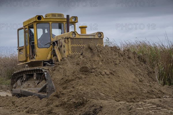 Bulldozer removes dam in the delta Danube river