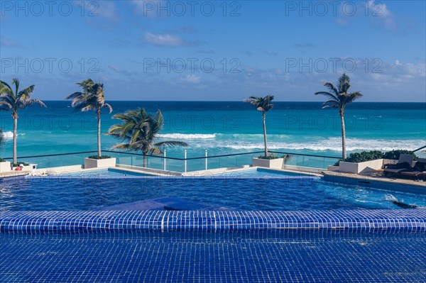 Swimming pool over the turquoise waters of Cancun