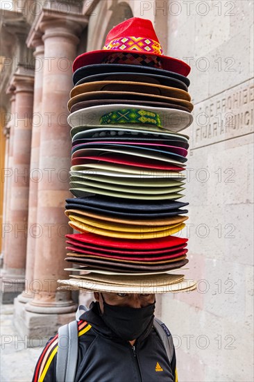 Souvenir seller with many hats on his head