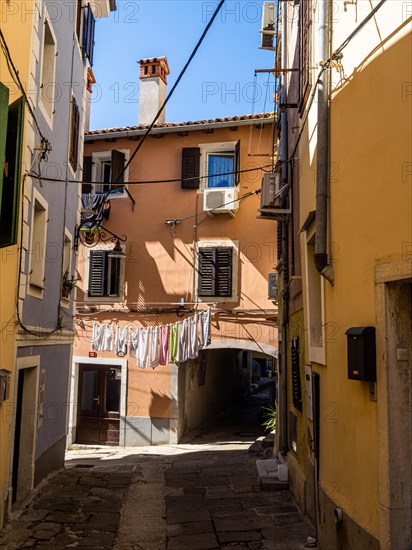 Laundry hanging to dry in a narrow alleyway of the old town of Izola