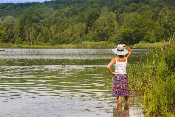 Woman with sun hat and skirt standing in the water