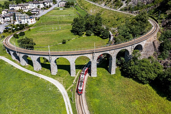 Aerial of a Train crossing the Brusio spiral viaduct