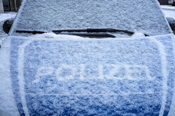 The snowed-in bonnet of a police car