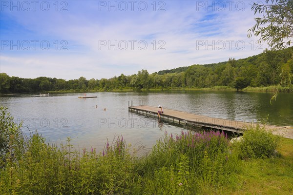 Woman with sun hat and skirt sitting on jetty