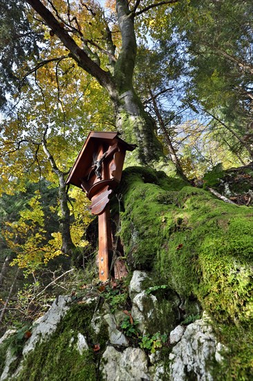 Memorial cross in autumnal mountain forest