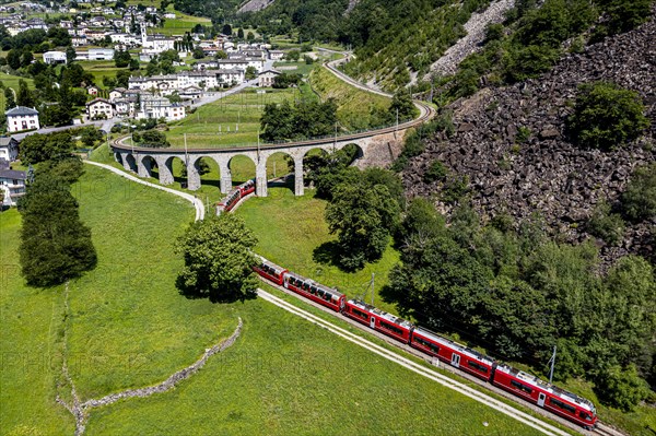 Aerial of a Train crossing the Brusio spiral viaduct