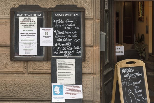 Behavioural advice during the pandemic in front of a restaurant 2021