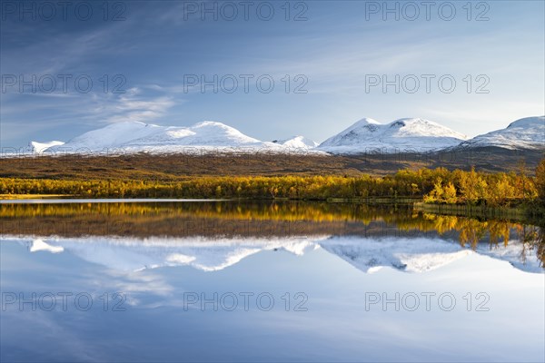 Snowy mountains in Abisko National Park reflected in lake Vuolio Njahkajavri