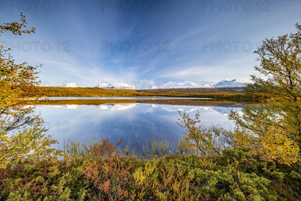 Snowy mountains in Abisko National Park reflected in lake Vuolio Njahkajavri