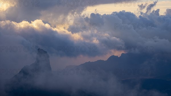 Roque Nublo shrouded in clouds at sunset