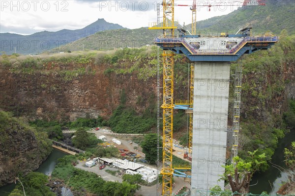 Construction site of bridge with crane across the Grand River of North West near the city of Beau Bassin