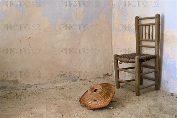 Traditional Spanish chair with straw hat in old house