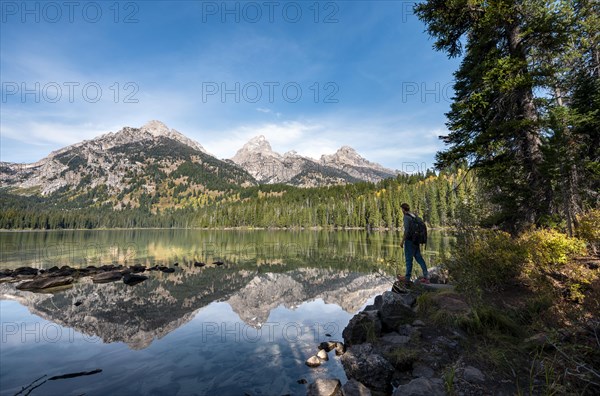 Young man standing by a lake