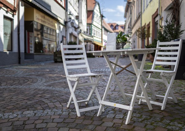 Wooden table and chair in a small alley