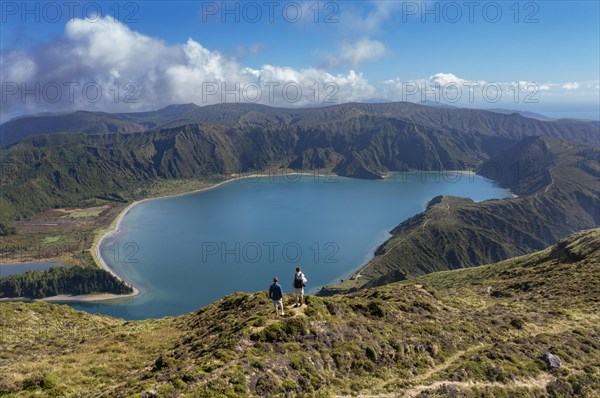 Hikers at the summit of Pico Barrosa with view to the crater lake Lagoa do Fogo