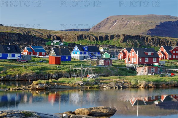 Wooden houses reflected in a calm body of water