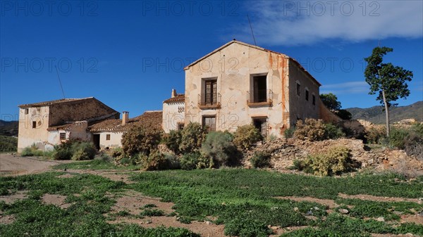 Frontal view of the finca El Garrobillo with house chapel in front of mountains