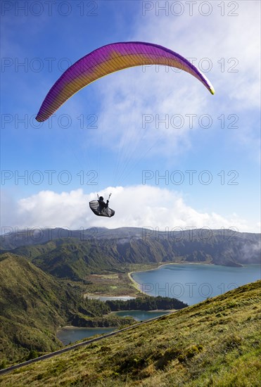 paraglider in flight over the crater lake Lagoa do Fogo