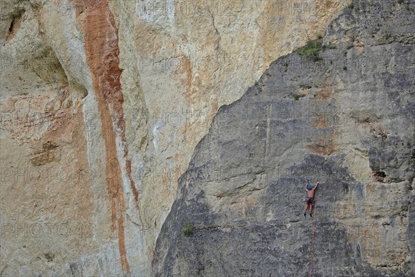 Climber on rope in rock face
