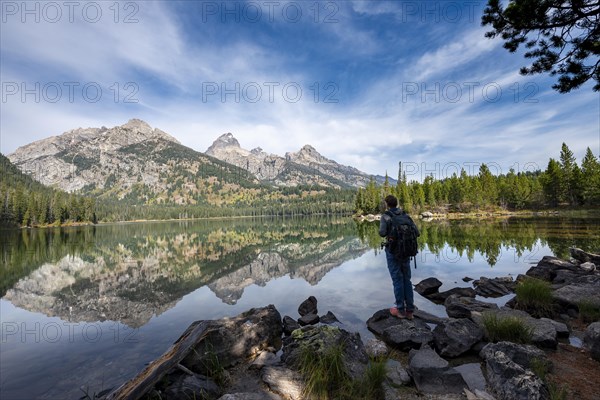 Young man standing by a lake