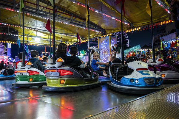 A small buy enjoys driving a bumper car at Santa Iria festival in Faro