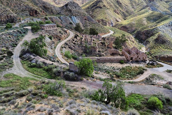 Roads and ruins on mine site in mountainous landscape from above