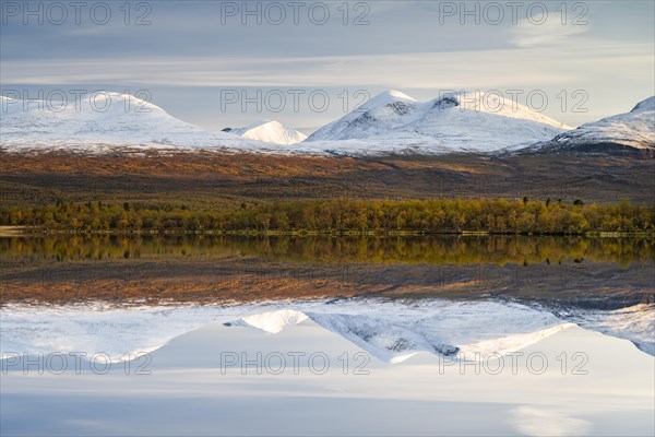 Snowy mountains in Abisko National Park reflected in lake Vuolio Njahkajavri