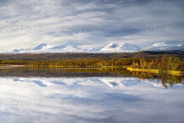 Snowy mountains in Abisko National Park reflected in lake Vuolio Njahkajavri