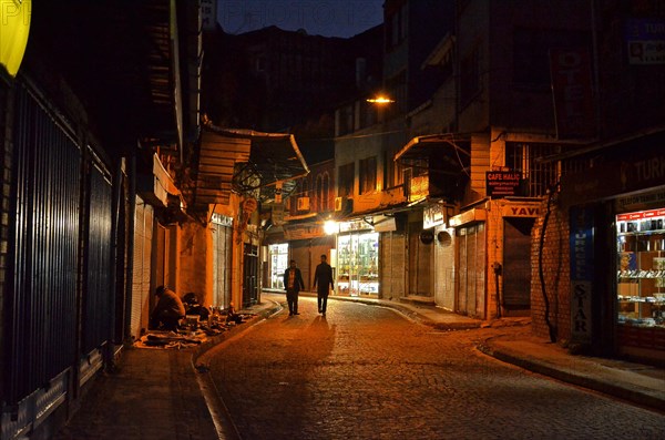 Two men on street in old town Eminoenue at night