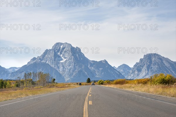 Country road in front of Grand Teton Range mountain