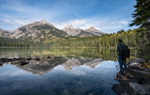 Young man standing by a lake