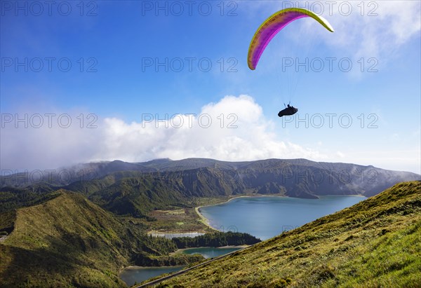 paraglider in flight over the crater lake Lagoa do Fogo