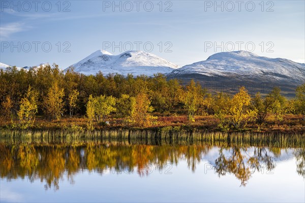 Snowy mountains in Abisko National Park reflected in lake Vuolio Njahkajavri