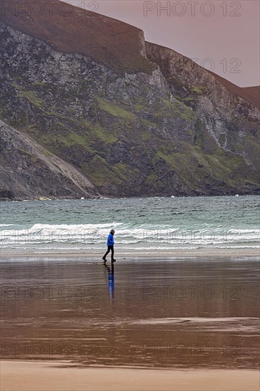 Walker walking along the beach in the evening