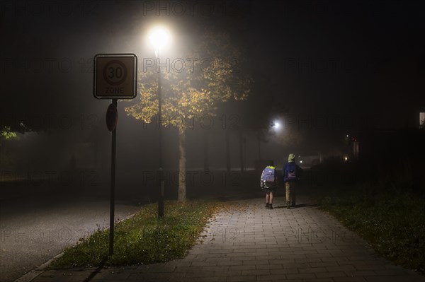 School children in foggy weather on their way to school in Markt Swabia