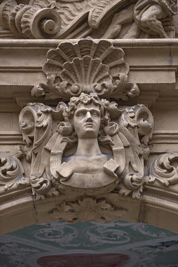 Man's head and shell in half relief above the entrance portal of the Baroque Boettinger House