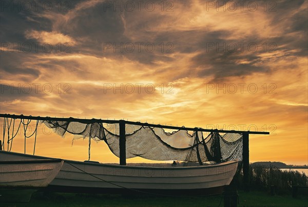 Suspended fishing nets and fishing boats in the sunset