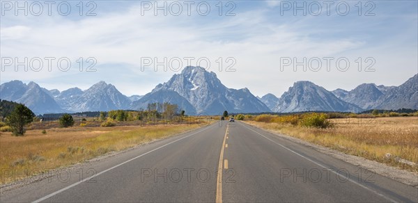 Country road in front of Grand Teton Range mountain