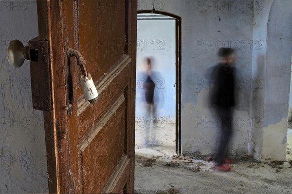 Open door with two people in abandoned house