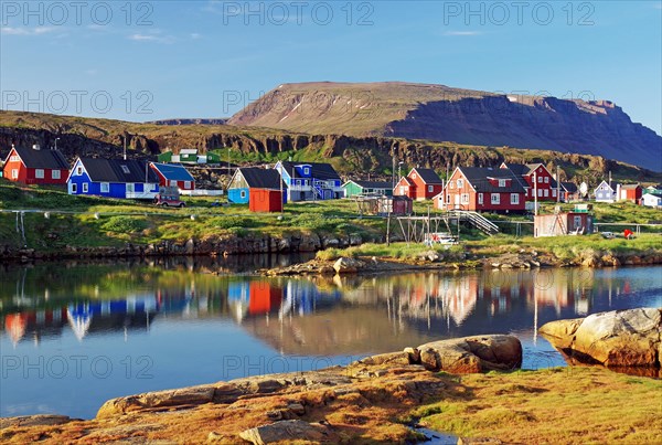 Wooden houses reflected in a calm body of water