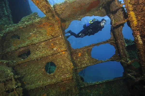 Diver looking into interior of sunken ship decaying rusting shipwreck Elviscot