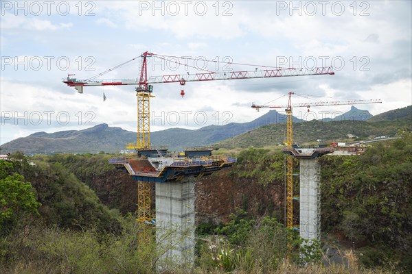 Construction site of bridge with crane across the Grand River of North West near the city of Beau Bassin