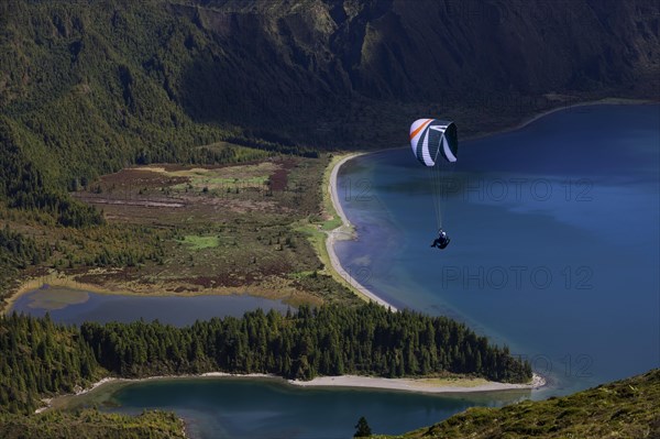 paraglider in flight over the crater lake Lagoa do Fogo