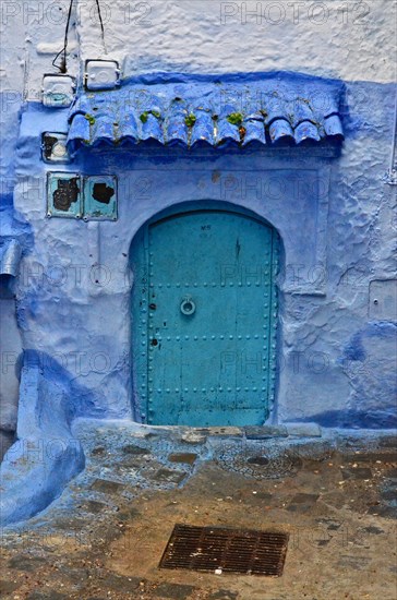 House entrance with mint-coloured door with blue wall