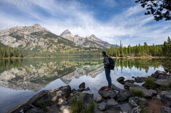 Young man standing by a lake